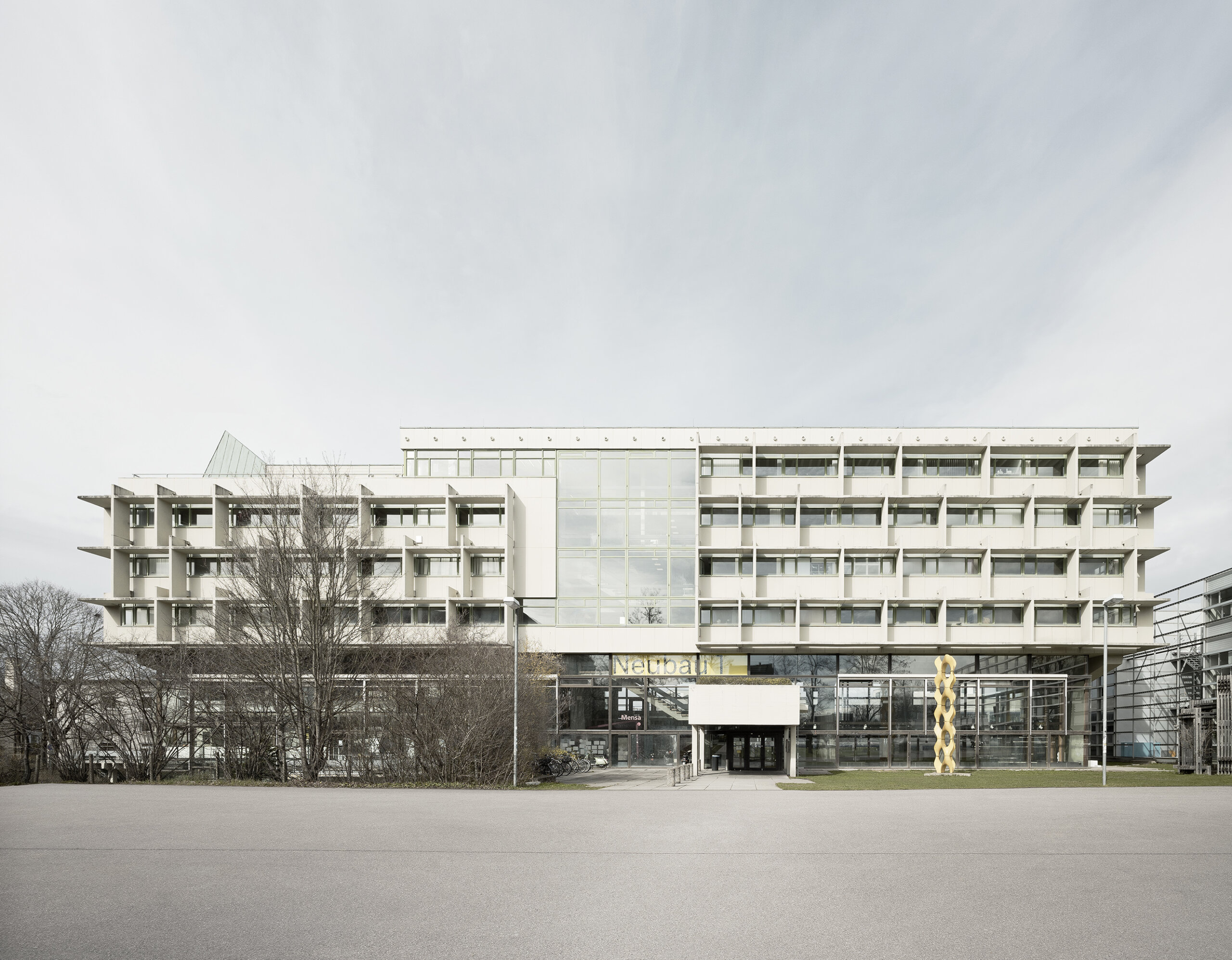 Modernes, mehrstöckiges Gebäude mit Glas- und Betonfassade.